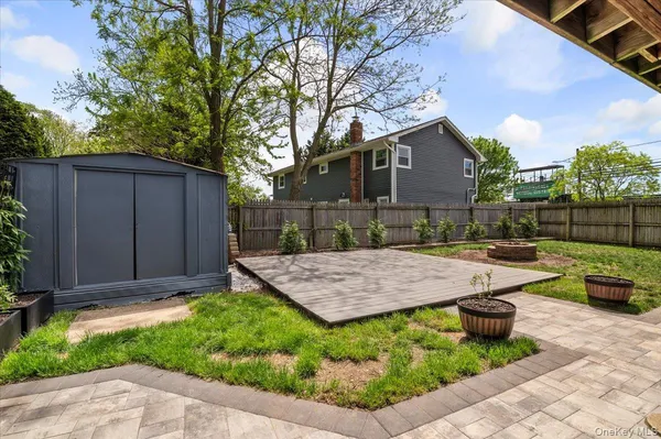 a view of backyard of house with outdoor seating and barbeque oven