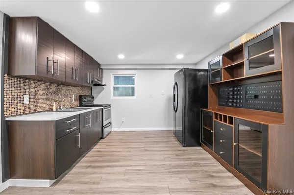 a large kitchen with stainless steel appliances kitchen island granite countertop a refrigerator and a stove top oven