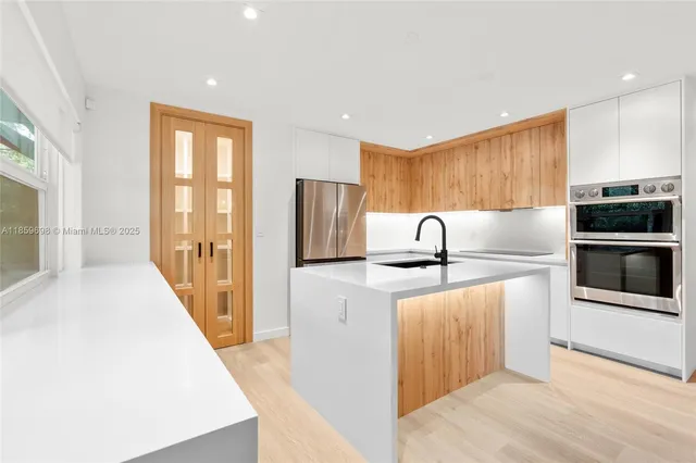a kitchen with kitchen island a sink appliances and cabinets