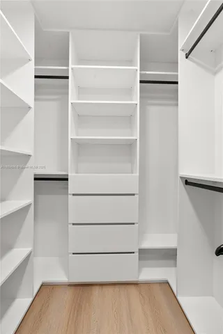 a view of walk in closet with empty racks