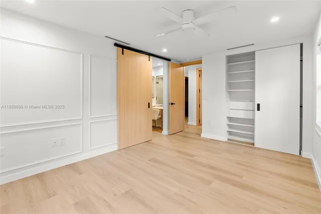 a view of empty room with wooden floor and window