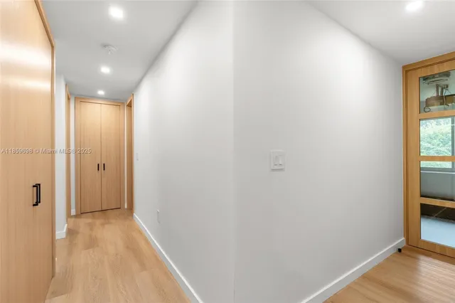 a view of hallway with a large window and wooden floor
