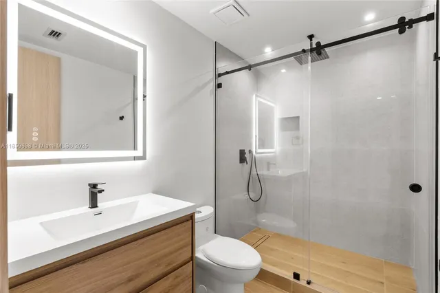 a bathroom with a sink a toilet and shower