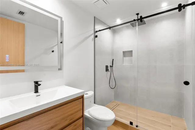 a bathroom with a sink a toilet and shower