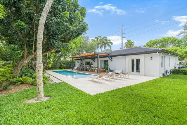 a view of a house with backyard and sitting area
