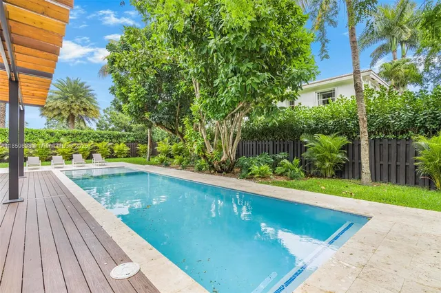 swimming pool view with a seating space and a garden