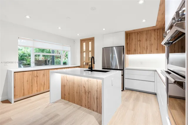 a kitchen with stainless steel appliances a refrigerator and a stove top oven