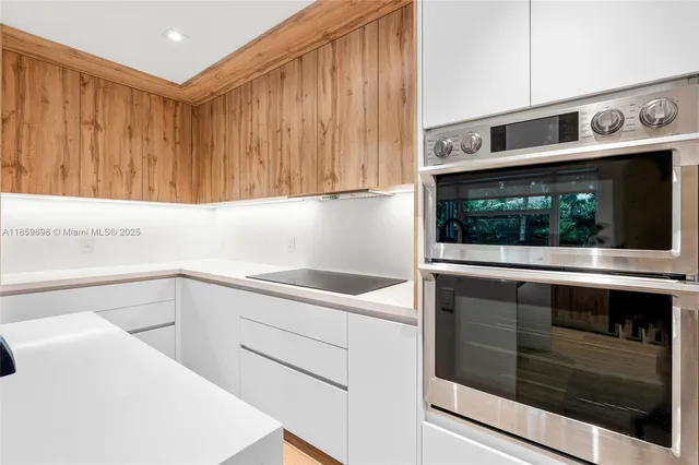 a kitchen with stainless steel appliances granite countertop a sink and a microwave