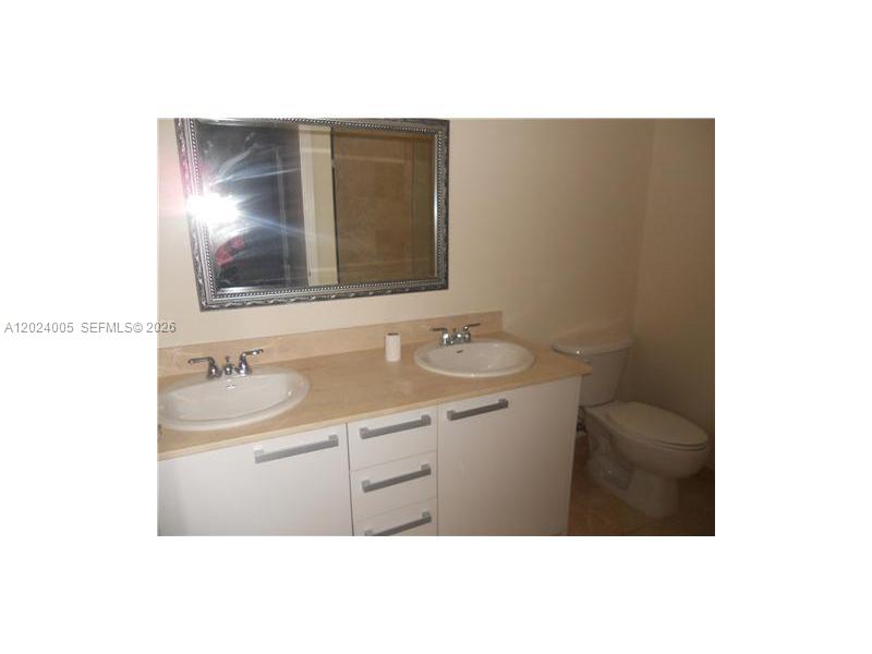 2525 Southwest 3rd Avenue, Unit 1006 Miami, FL 33129 - Photo 7 of 13 a bathroom with a sink and a mirror