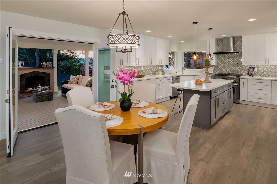 1533 33rd Avenue Seattle, WA 98122 - Photo 11 of 28 a kitchen with a dining table chairs stainless steel appliances and cabinets