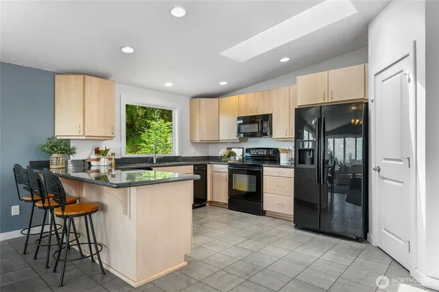 a kitchen with a sink a counter top space stainless steel appliances and cabinets