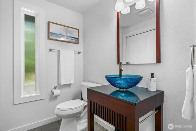a bathroom with a toilet a sink and mirror