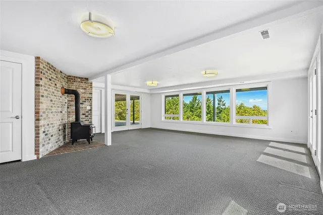 a view of an empty room with a fireplace and a large window