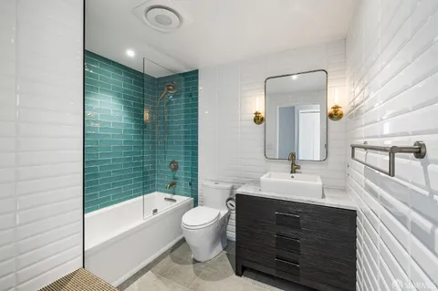 a bathroom with a double vanity sink toilet mirror and bathtub
