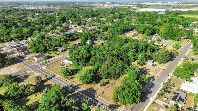 an aerial view of residential house with outdoor space and trees all around