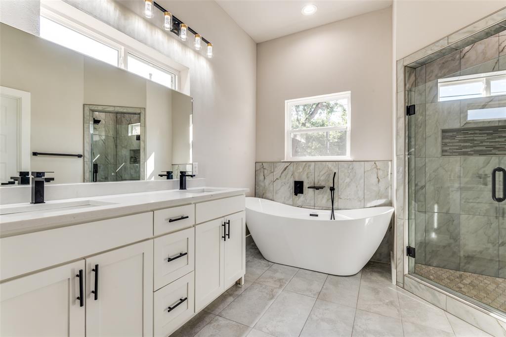 4113 Metropolitan Avenue Dallas, TX 75210 - Photo 17 of 30 a spacious bathroom with a bathtub sink and mirror