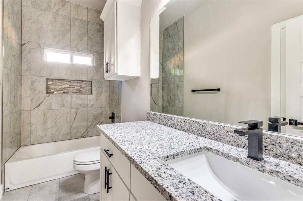 4113 Metropolitan Avenue Dallas, TX 75210 - Photo 21 of 30 a bathroom with a granite countertop sink a toilet and bathtub