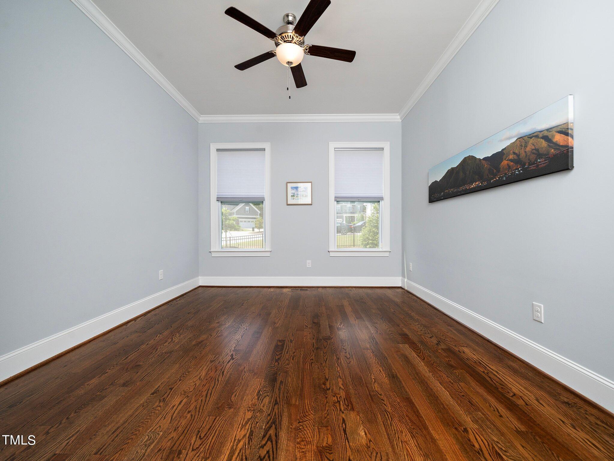 7733 Wilderness Road Raleigh, NC 27613 - Photo 11 of 37 a view of empty room with wooden floor and fan