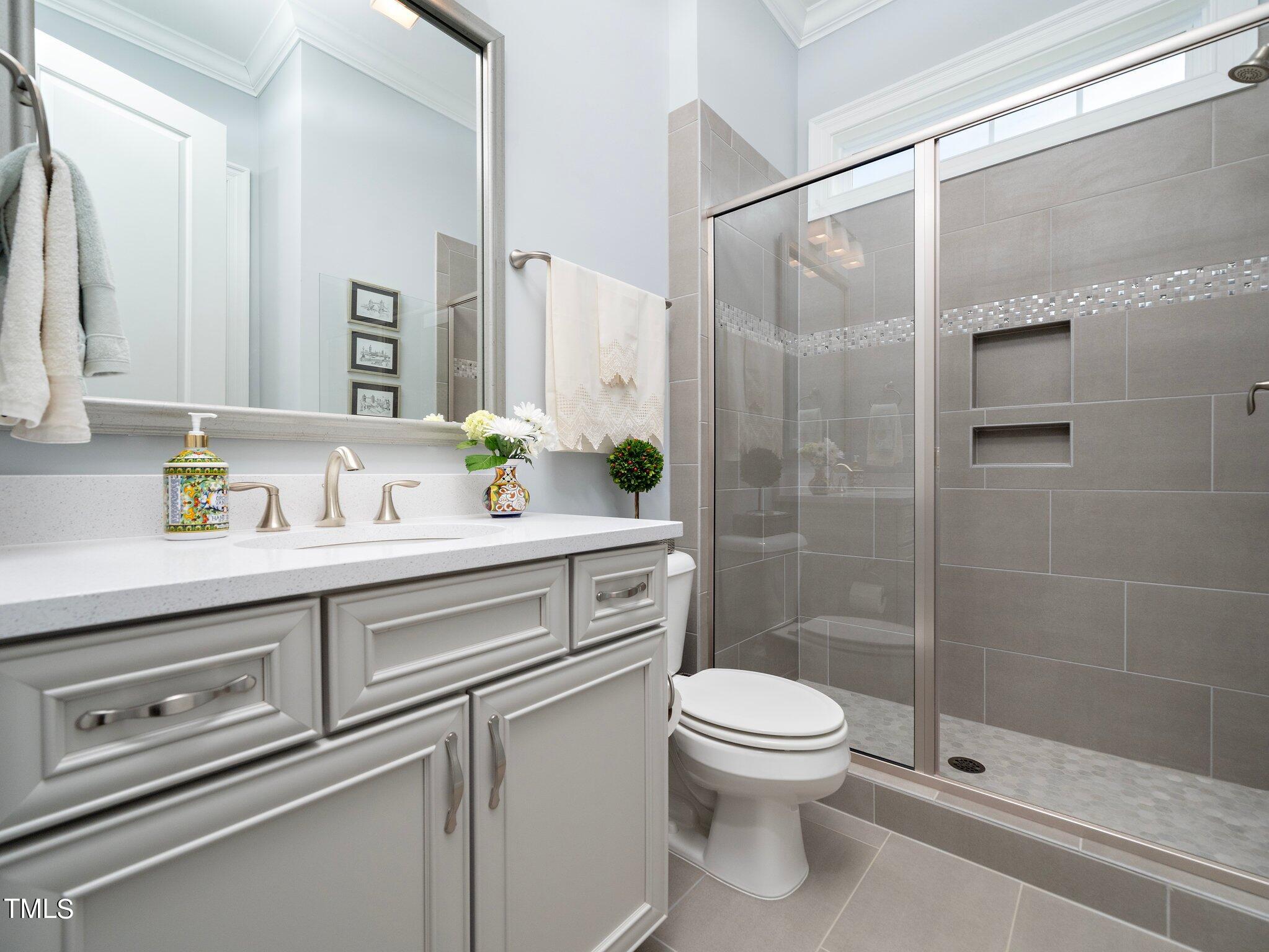 7733 Wilderness Road Raleigh, NC 27613 - Photo 12 of 37 a bathroom with a shower sink vanity mirror and toilet