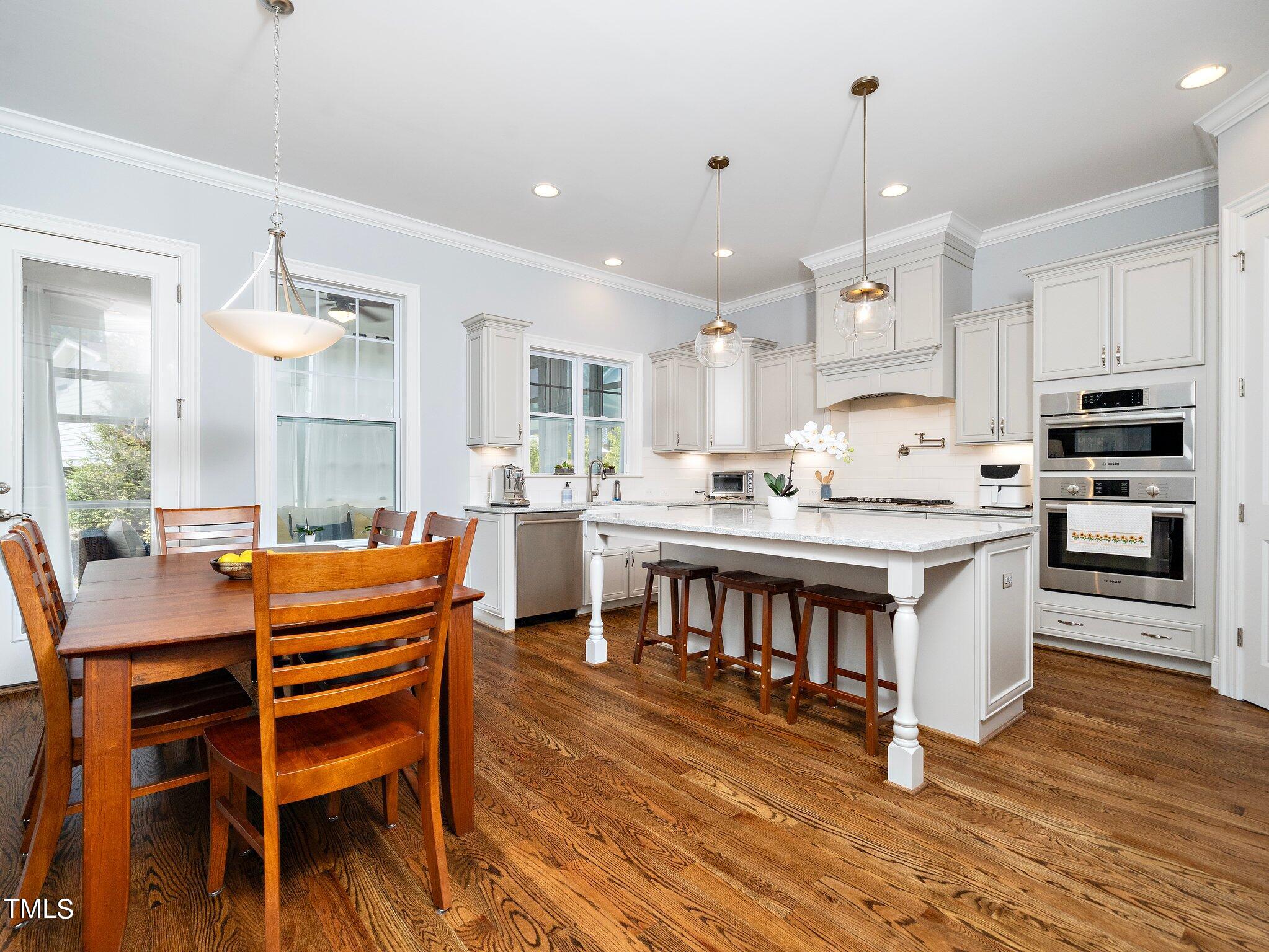 7733 Wilderness Road Raleigh, NC 27613 - Photo 14 of 37 a kitchen with a table chairs sink and cabinets