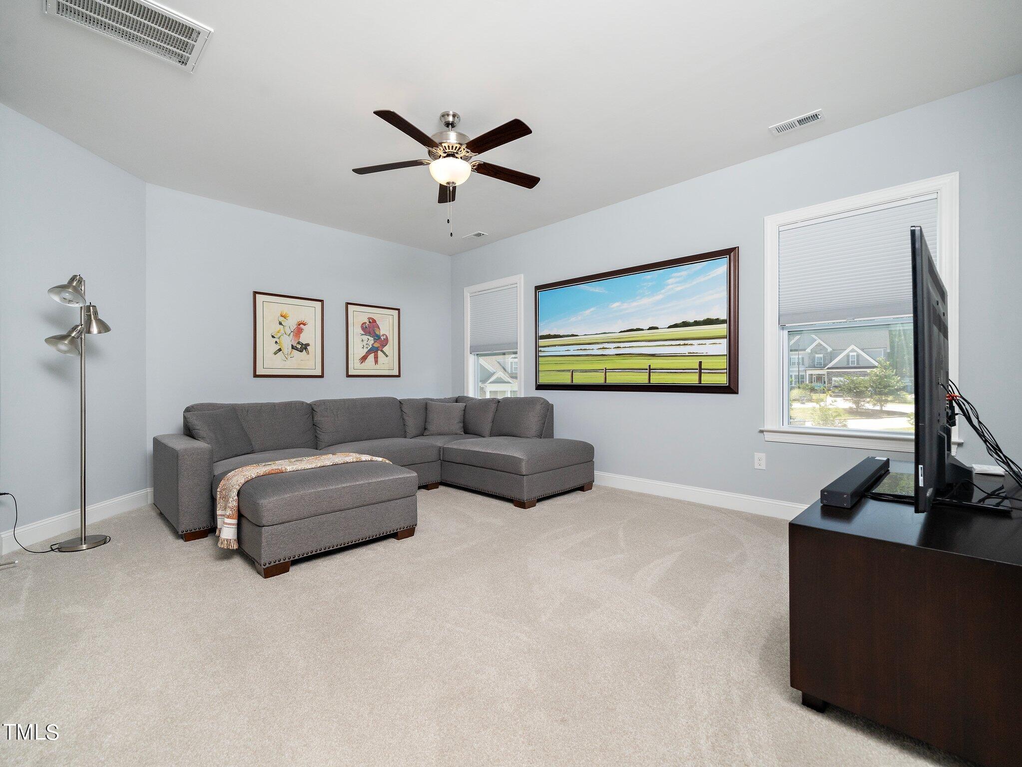 7733 Wilderness Road Raleigh, NC 27613 - Photo 21 of 37 a living room with furniture and a flat screen tv