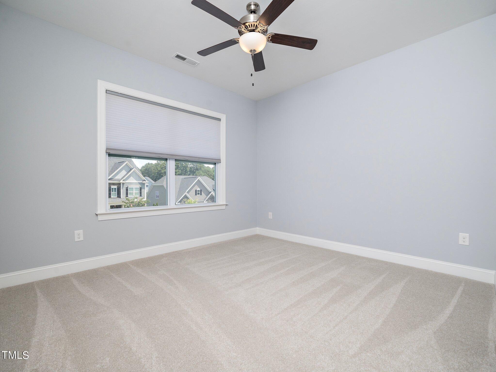 7733 Wilderness Road Raleigh, NC 27613 - Photo 28 of 37 an empty room with window and ceiling fan