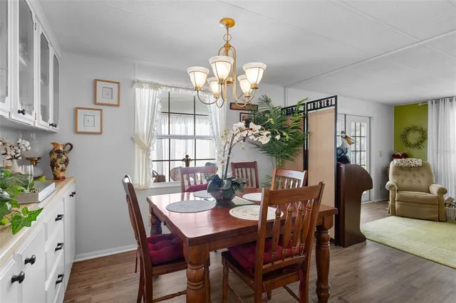 a view of a dining room with furniture a chandelier and wooden floor