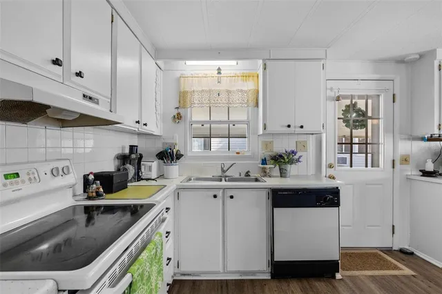 a kitchen with a sink a stove and cabinets