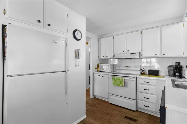 a kitchen with refrigerator cabinets and wooden floor