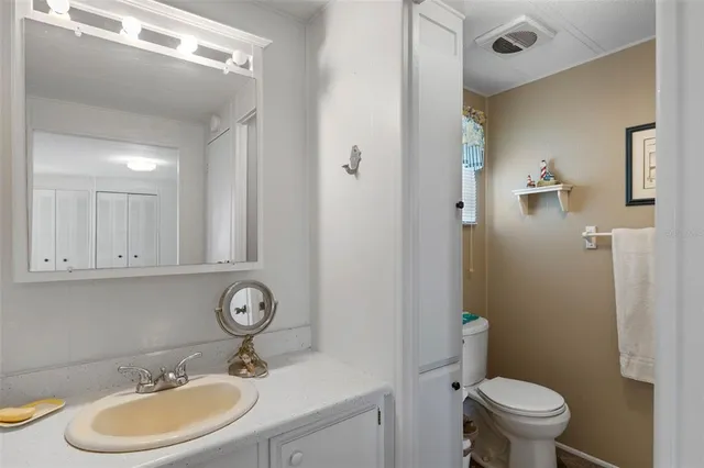a bathroom with a sink a toilet and a mirror
