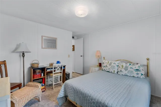 a bedroom with a bed a table and chair