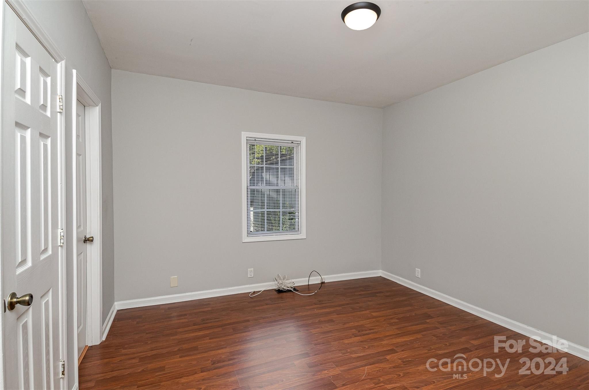 484 Cook Street Northwest Concord, NC 28025 - Photo 11 of 32 an empty room with wooden floor and windows