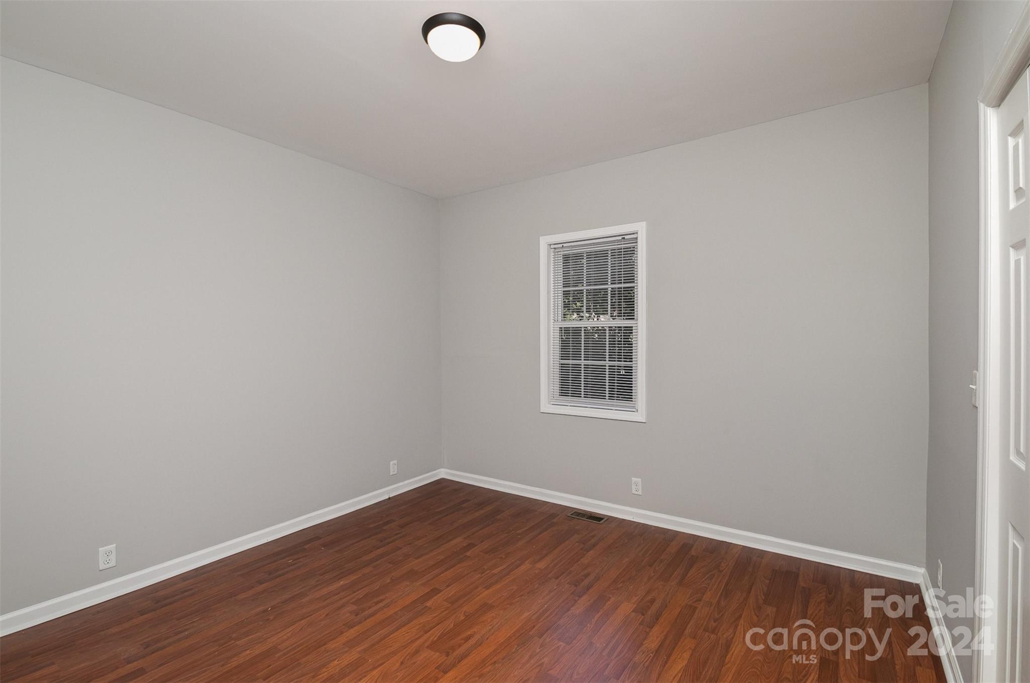 484 Cook Street Northwest Concord, NC 28025 - Photo 13 of 32 an empty room with wooden floor and windows