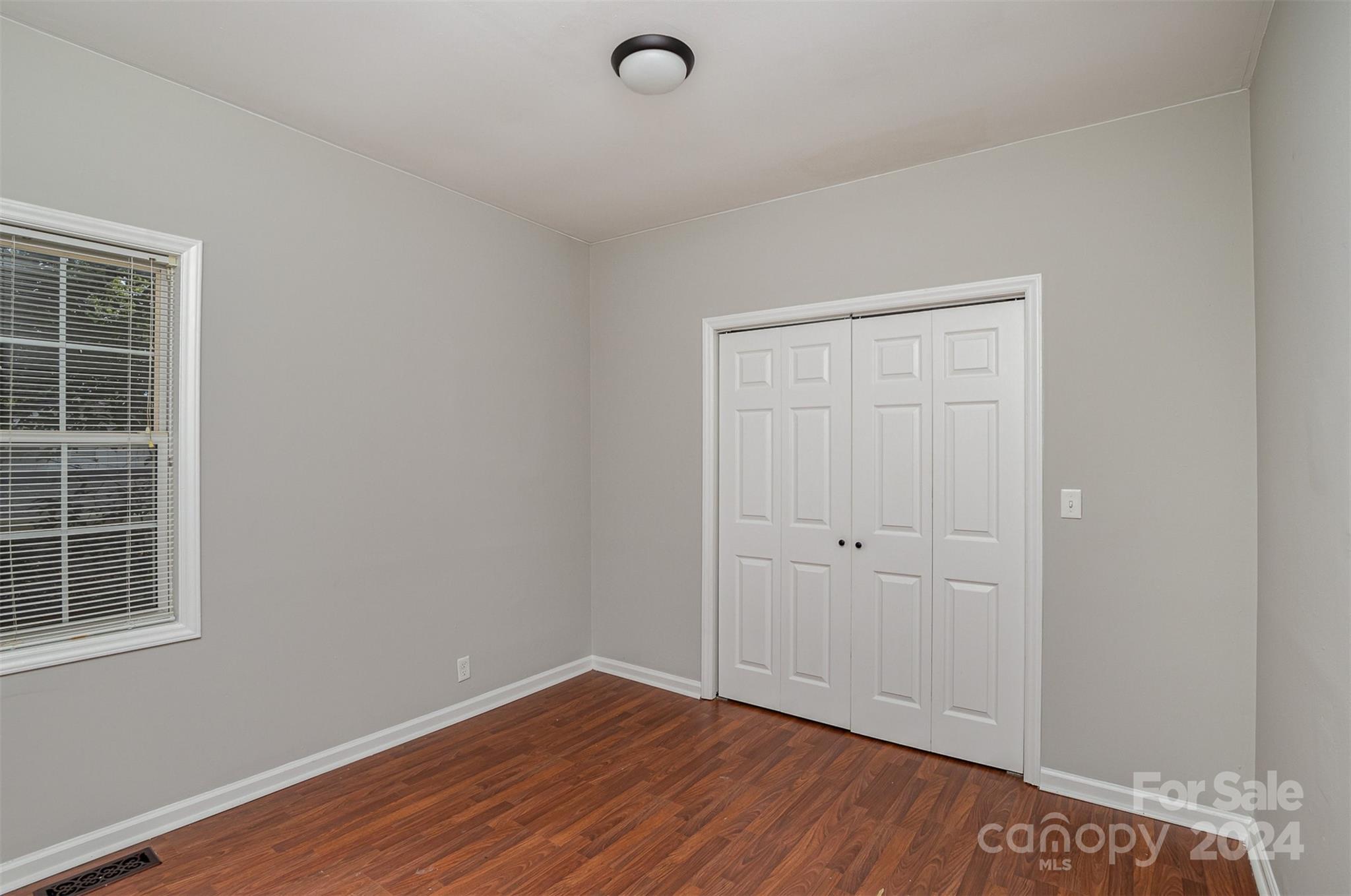 484 Cook Street Northwest Concord, NC 28025 - Photo 15 of 32 a view of an empty room with wooden floor and windows