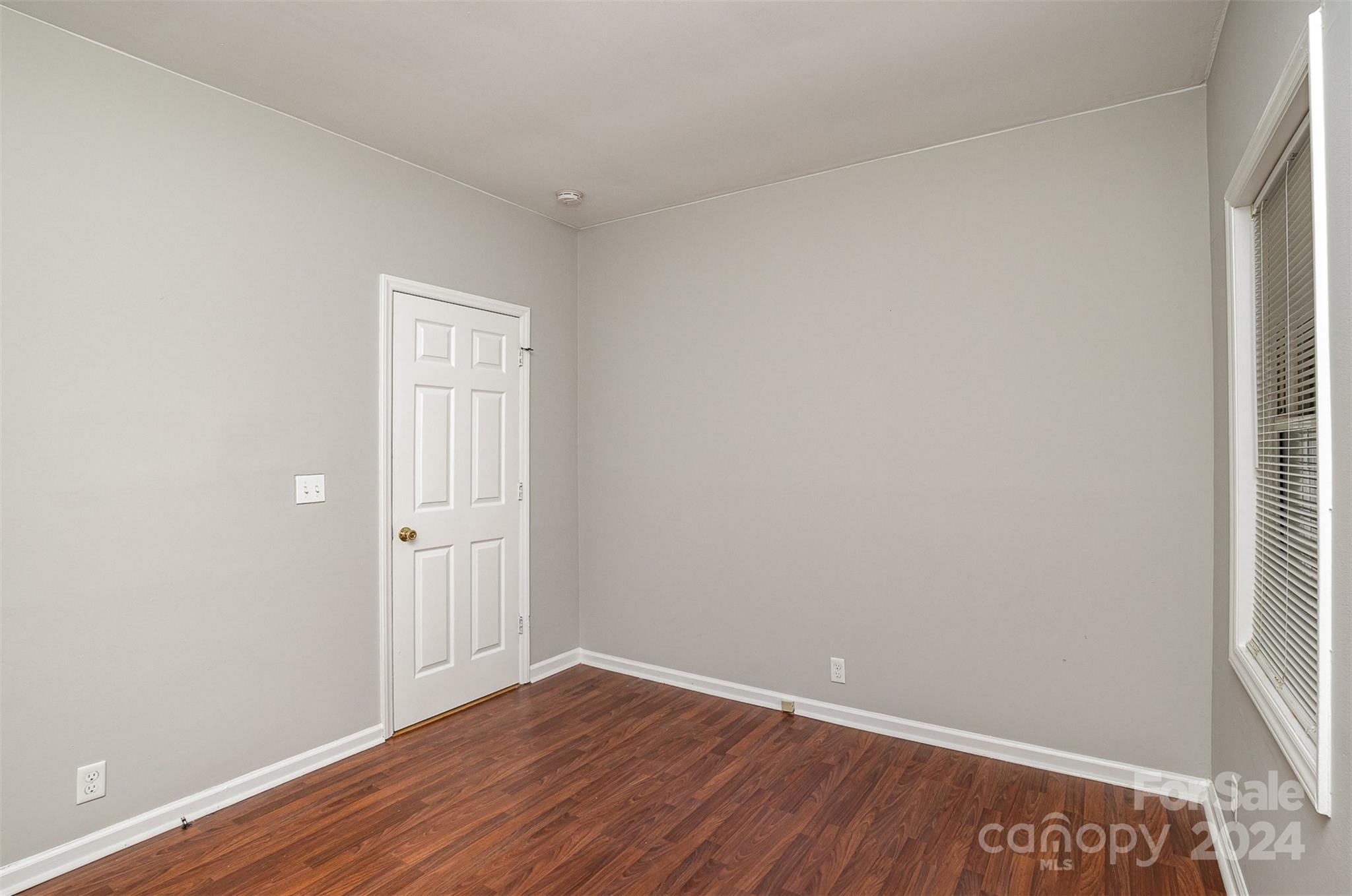 484 Cook Street Northwest Concord, NC 28025 - Photo 16 of 32 a view of an empty room with wooden floor and a window