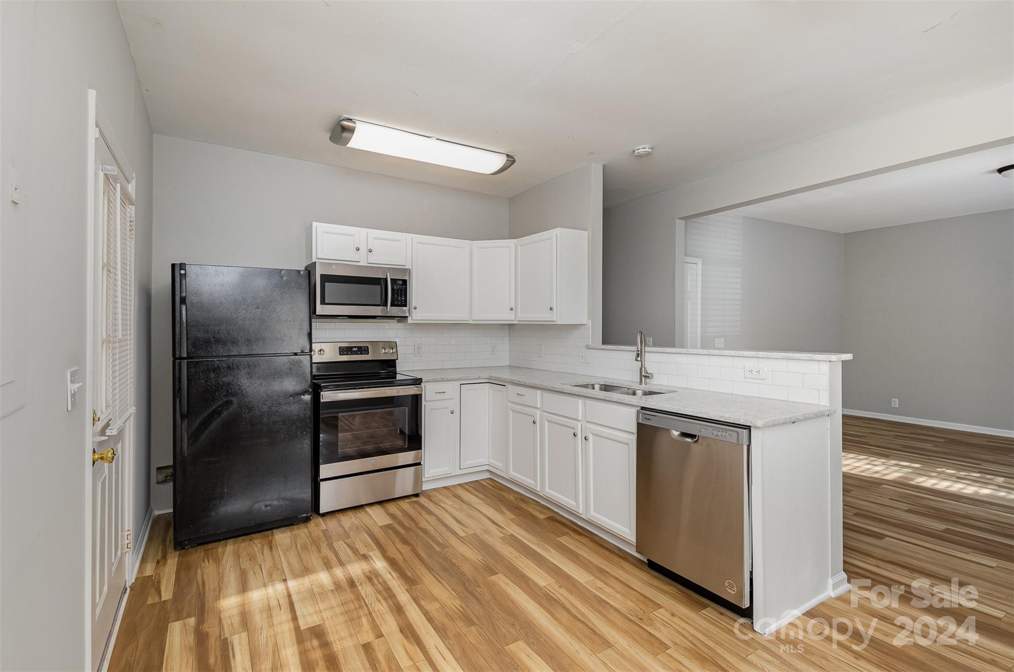484 Cook Street Northwest Concord, NC 28025 - Photo 5 of 32 a kitchen with granite countertop a refrigerator and a sink