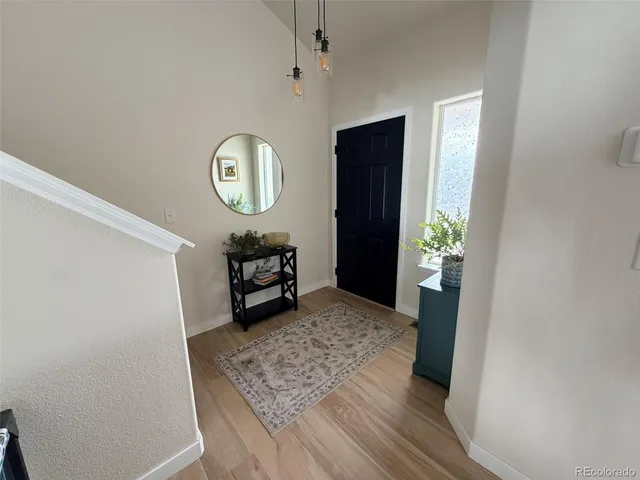 a view of a hallway to a closet and wooden floor