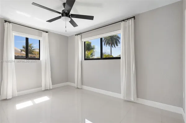 a view of an empty room with window and cabinet