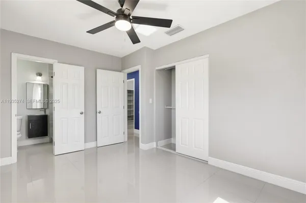 an empty room with closet and a ceiling fan