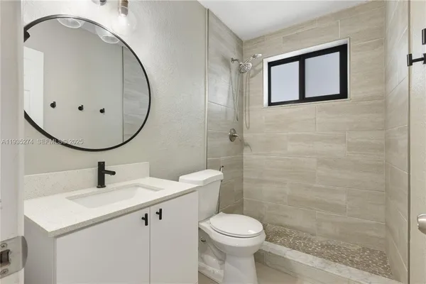 a bathroom with a sink a toilet and mirror