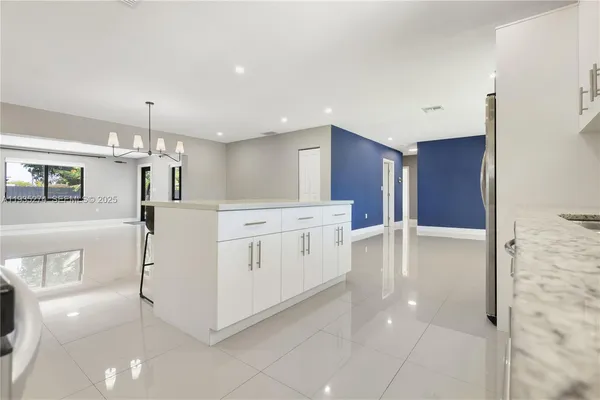 a kitchen with kitchen island a stove a refrigerator and a sink with wooden floor
