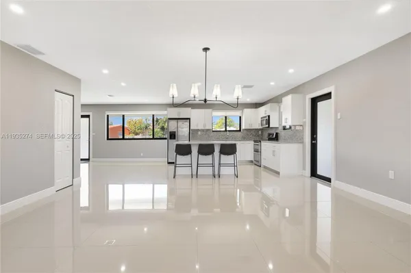 a view of a kitchen with dining area refrigerator and window