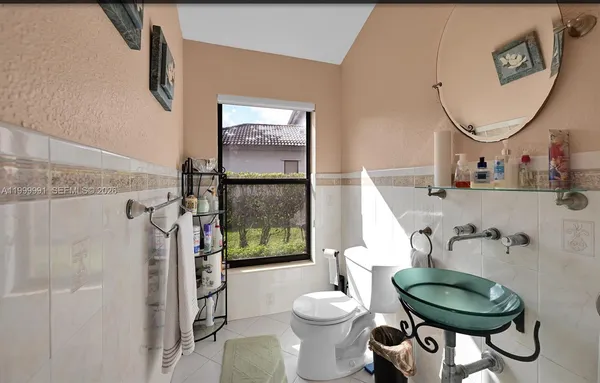 a bathroom with a toilet a sink and a mirror