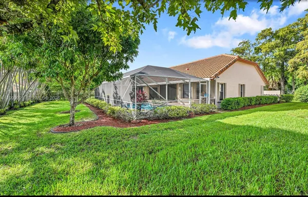 a front view of a house with a yard and green space