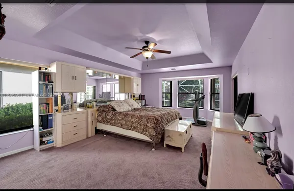 a spacious bedroom with a bed and a chandelier