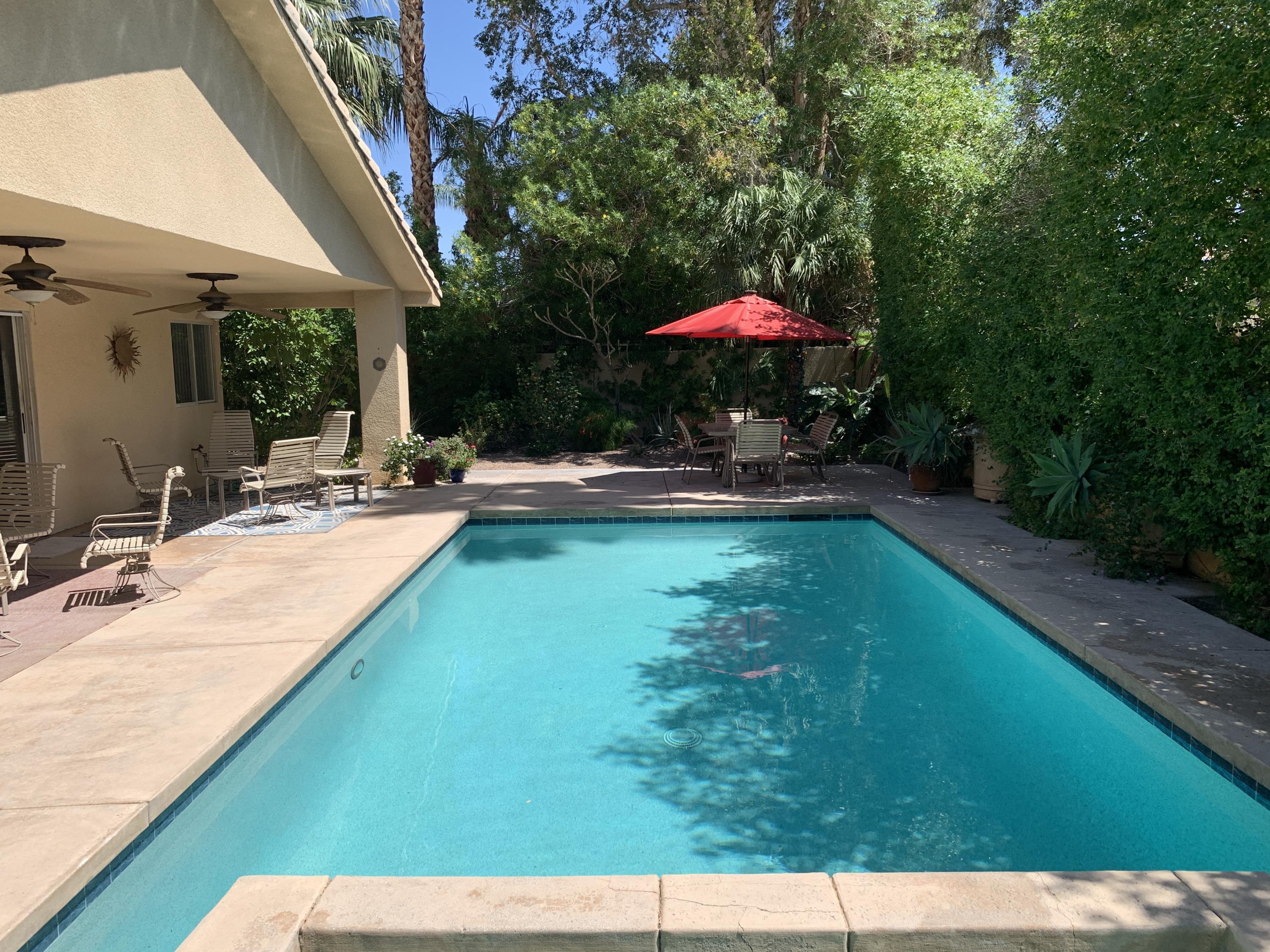 68921 Risueno Road Cathedral City, CA 92234 - Photo 1 of 20 a view of swimming pool with a table and chairs under an umbrella
