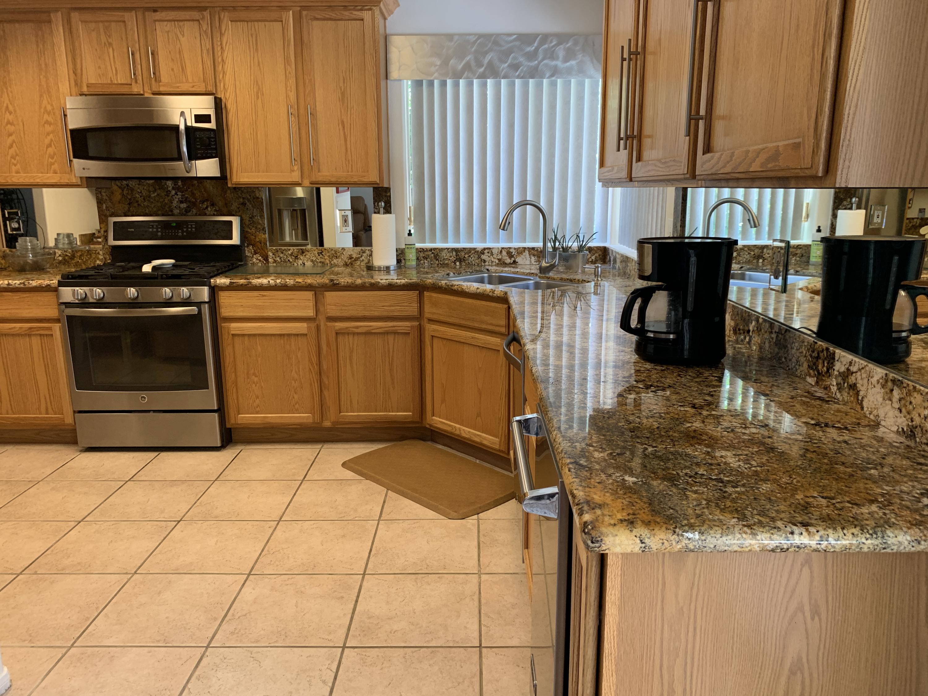 68921 Risueno Road Cathedral City, CA 92234 - Photo 15 of 20 a kitchen with stainless steel appliances granite countertop a stove a sink and a microwave