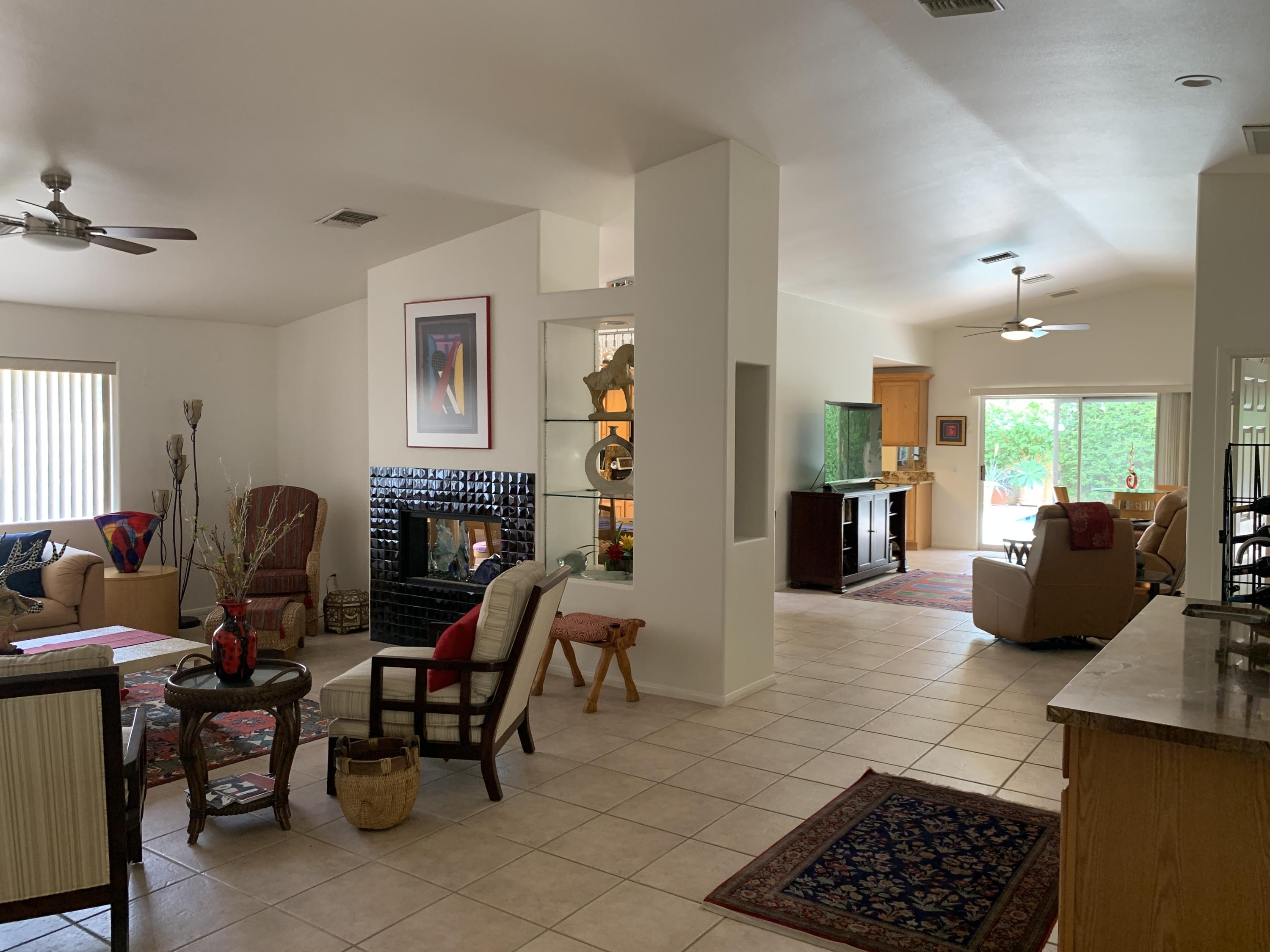68921 Risueno Road Cathedral City, CA 92234 - Photo 6 of 20 a living room with furniture a dining table and a fireplace