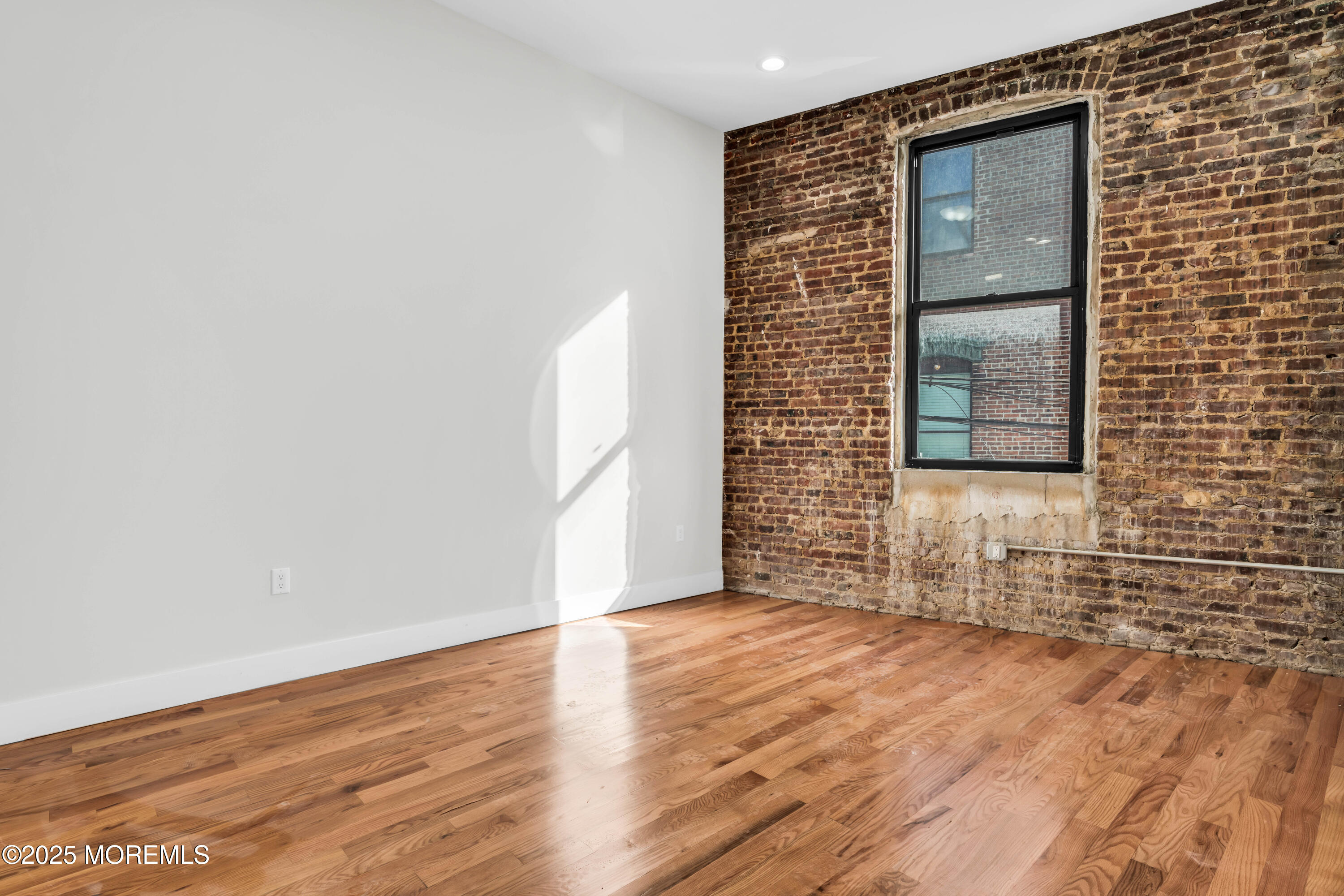 7 Broad Street, Unit 1 Red Bank, NJ 07701 - Photo 14 of 28 a view of an empty room with wooden floor and a window