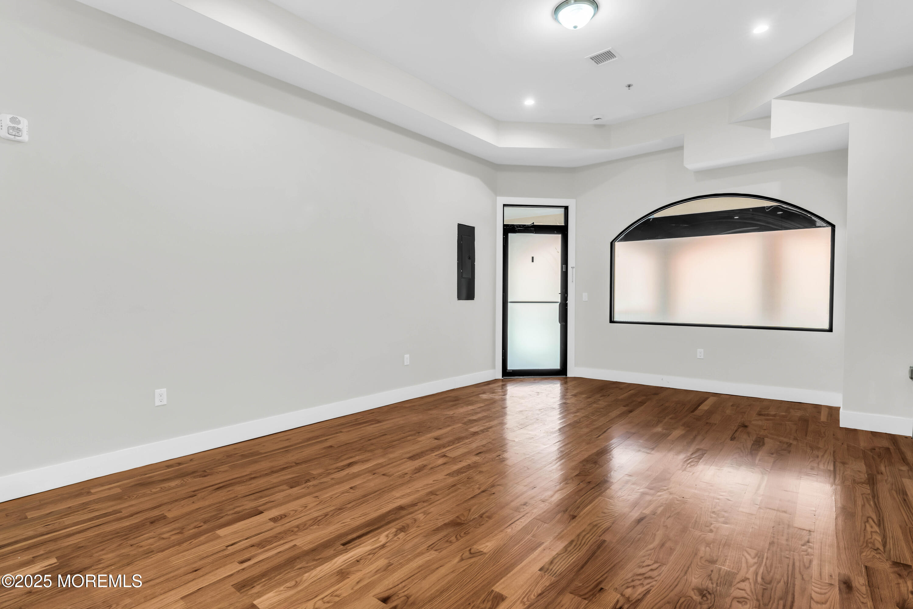 7 Broad Street, Unit 1 Red Bank, NJ 07701 - Photo 3 of 28 an empty room with wooden floor and entryway